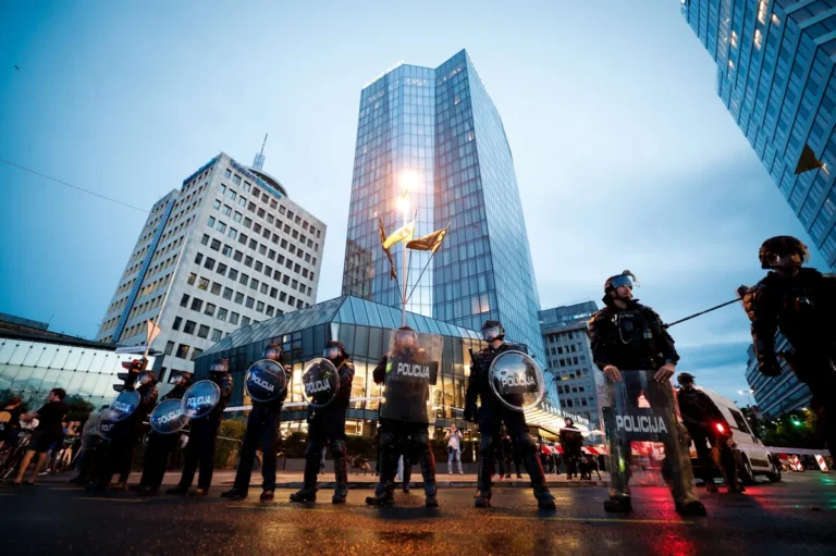 (VIDEO) Vroče v bližnjih srečanjih med robokopi in protestniki – Protestnik z pijačo iz pločevinke polival policista z motorjem po čeladi
